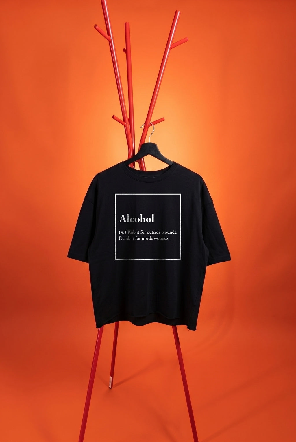 Black t-shirt with 'Alcohol' text on a hanger against an orange background