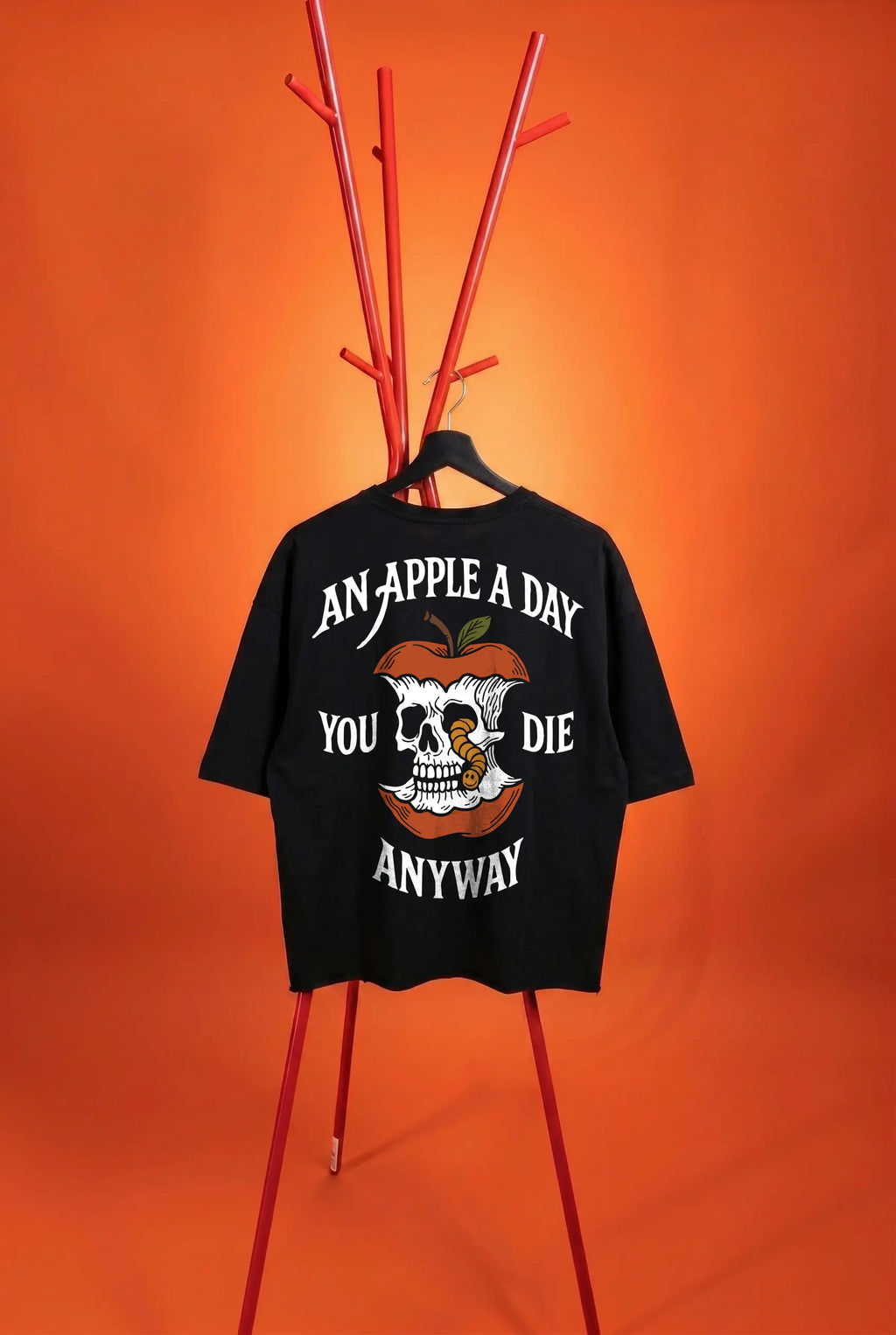 Black t-shirt with graphic design and text on a stand against an orange background