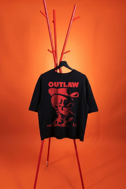 Black t-shirt with 'Outlaw' graphic on a red stand against an orange background