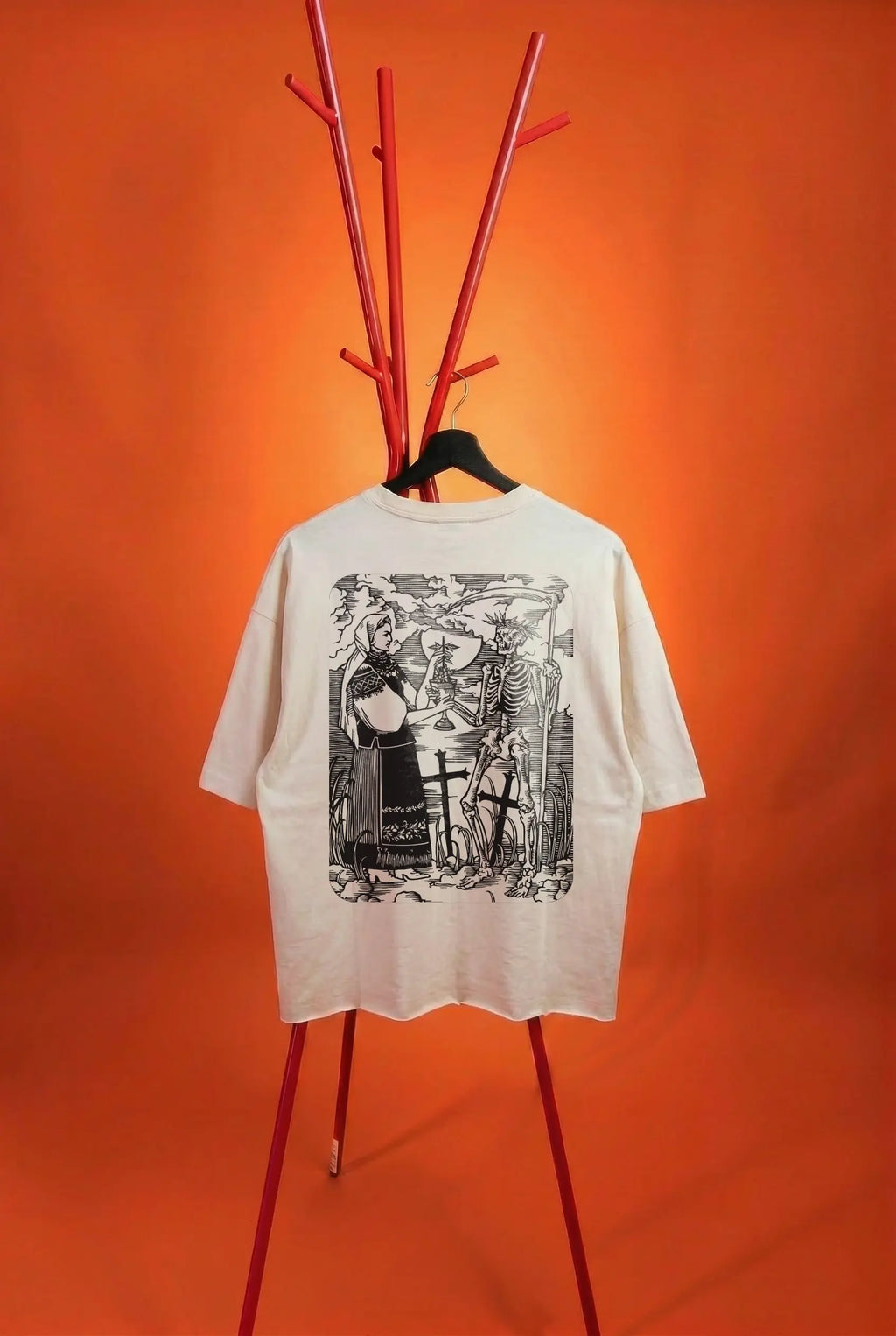 White t-shirt with black graphic design on a red stand against an orange background