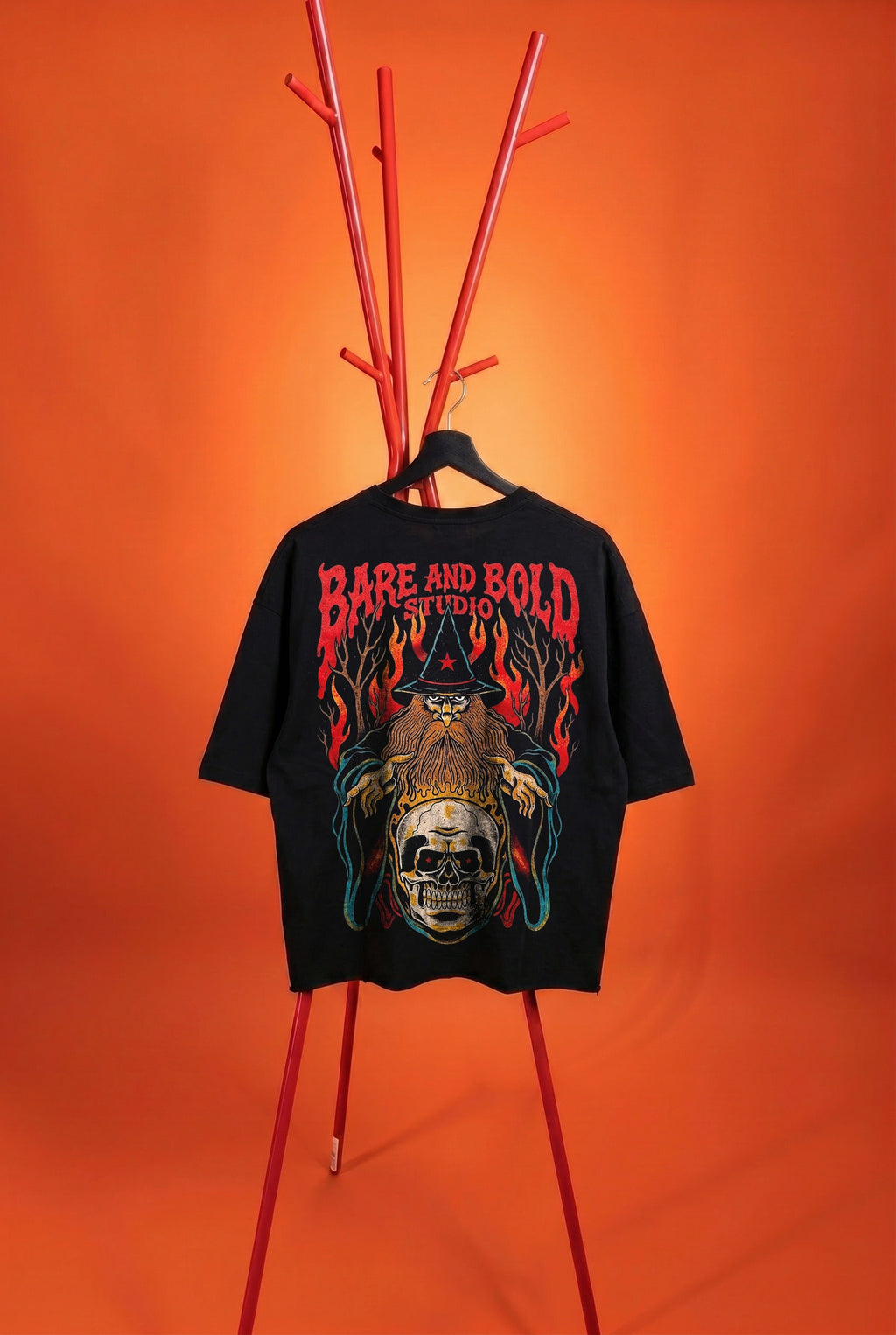 Black t-shirt with graphic design and 'Bare and Bold' text on a red stand against an orange background