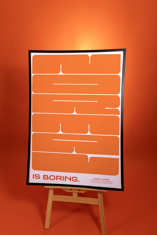 Poster with text 'IS BORING.' on an easel against an orange background