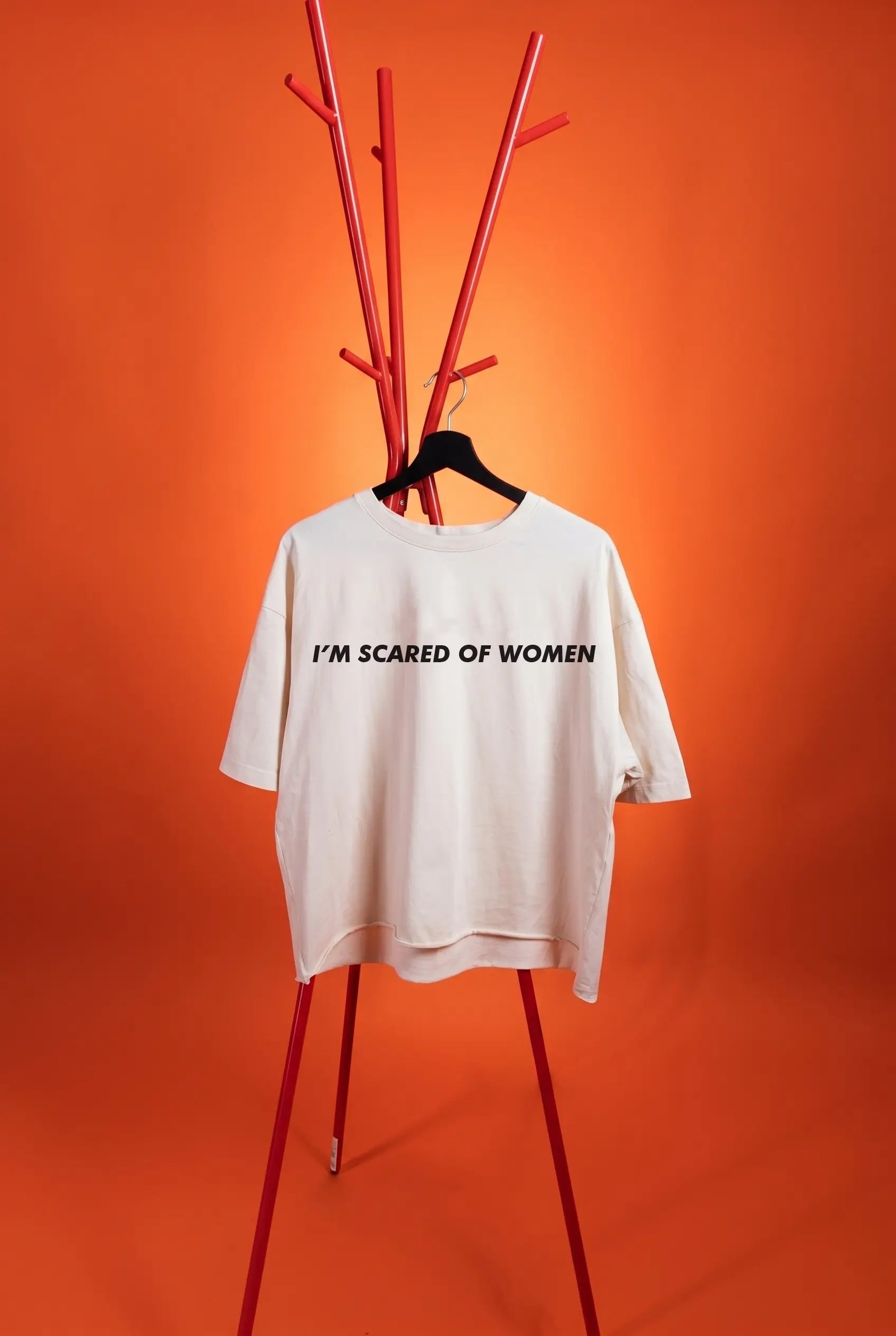 white t-shirt with text "i'm scared of Women" on an orange background