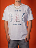A man wearing a white graphic t-shirt with the text 'SOME DO SOME WON'T SOME WILL SOME MIGHT I MIGHT' arranged around a hand drawing on a skateboard, set against a solid orange background.