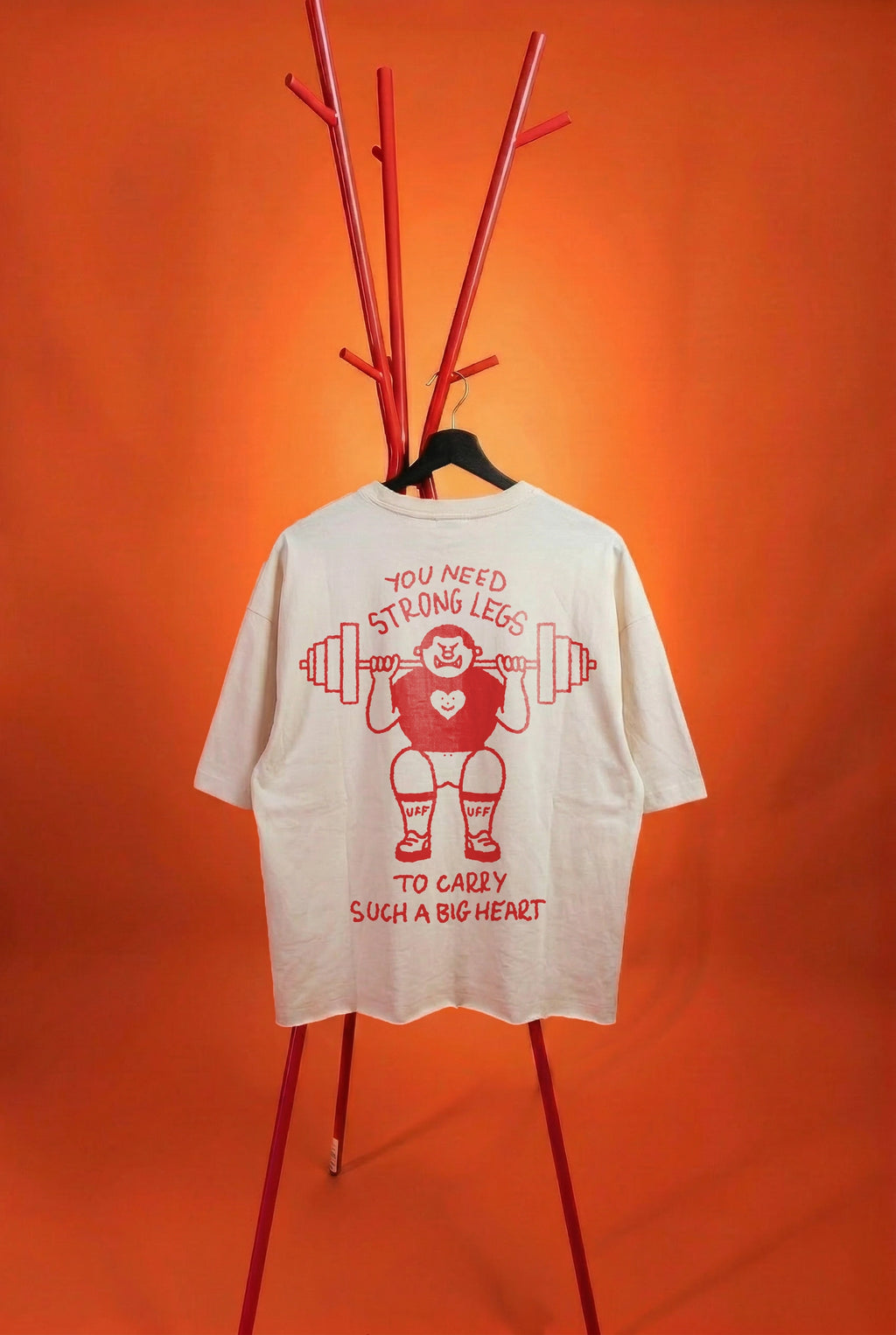 white t-shirt with a strong guy graffic on an orange background
