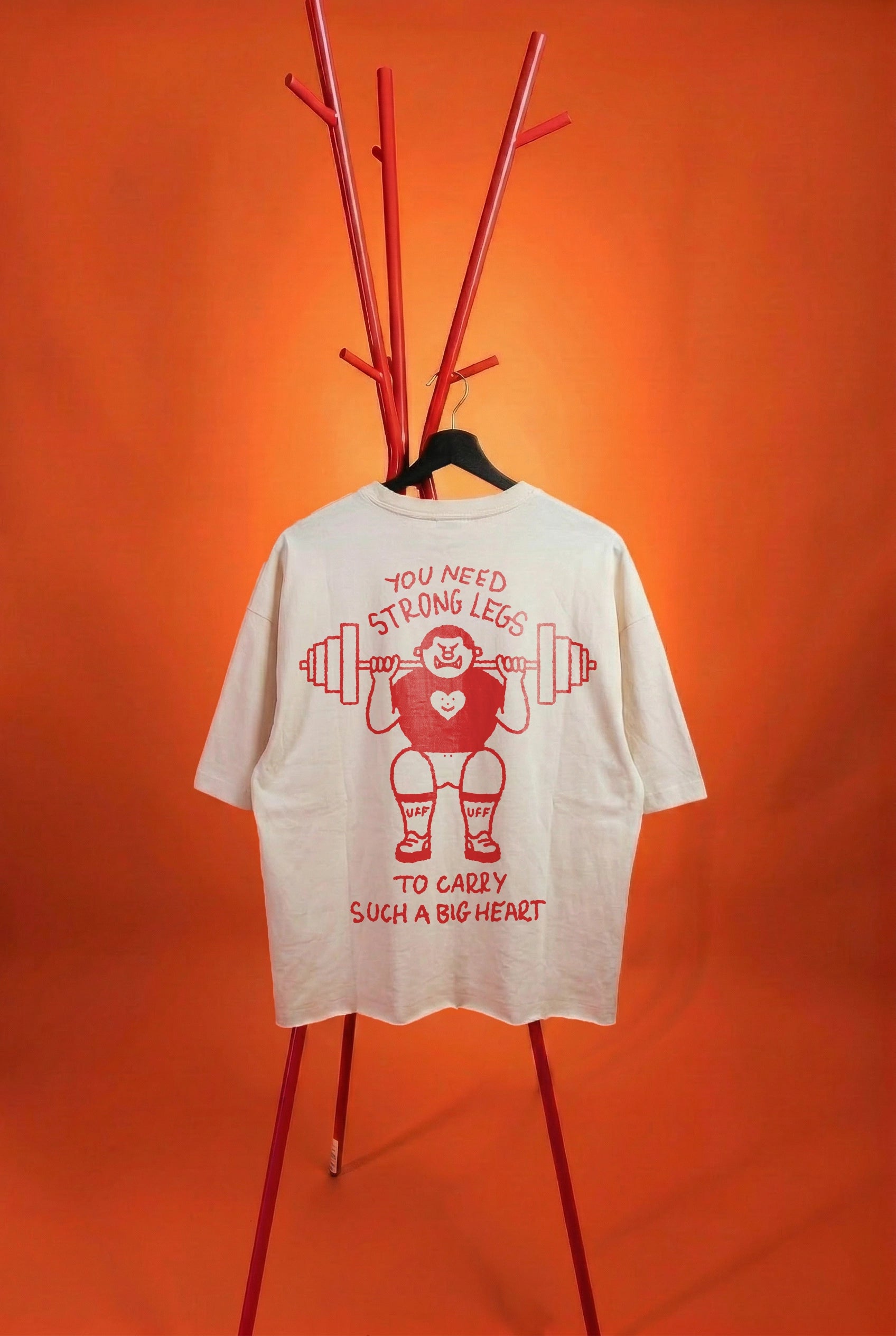 white t-shirt with a strong guy graffic on an orange background
