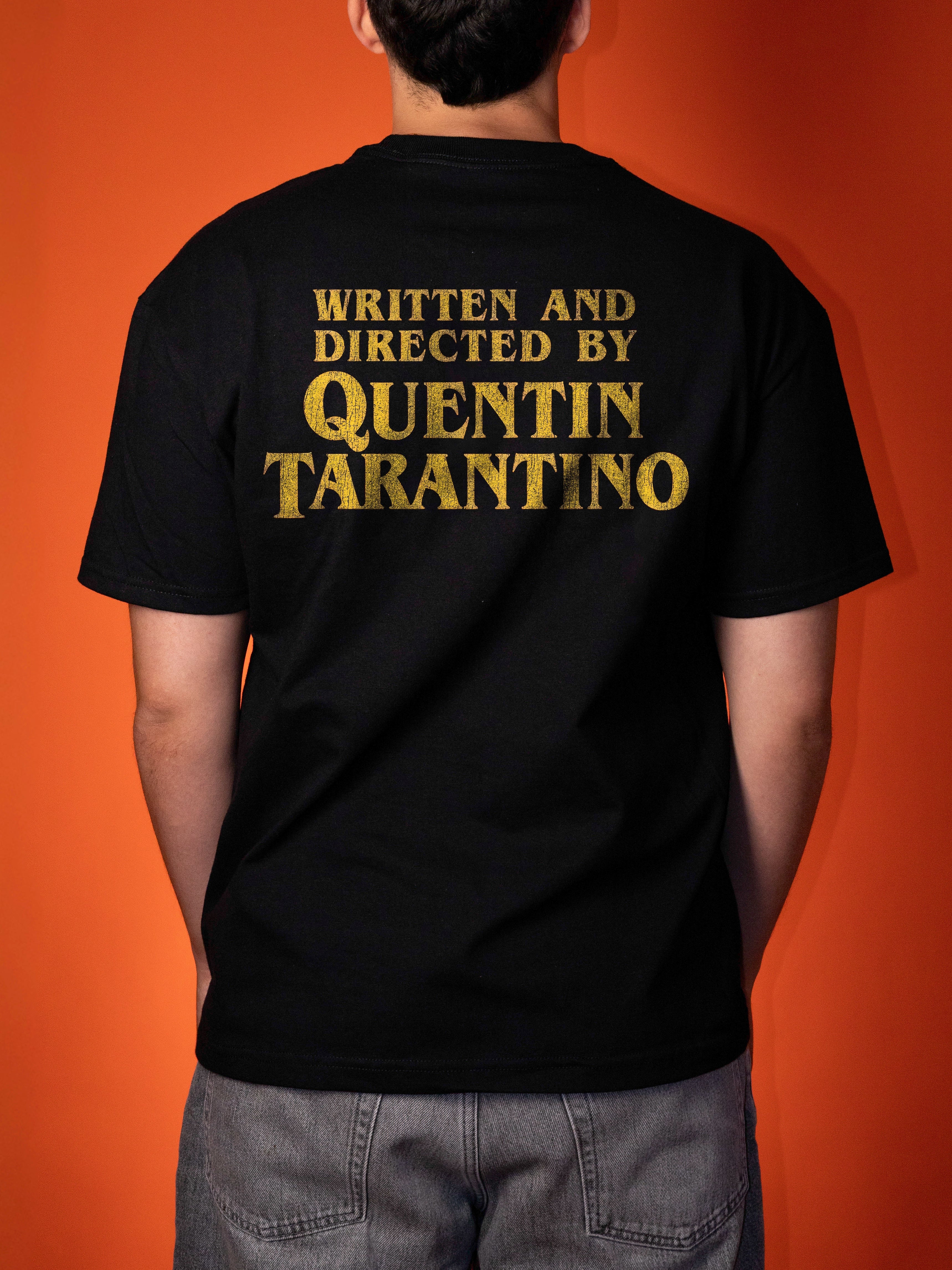 A person shown from the back wearing a black t-shirt with 'WRITTEN AND DIRECTED BY QUENTIN TARANTINO' printed in distressed gold lettering, set against a solid orange background.
